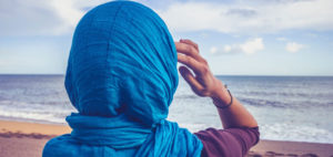 Muslim woman looking out to sea.