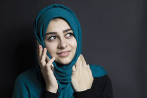 Muslim woman smiling on phone