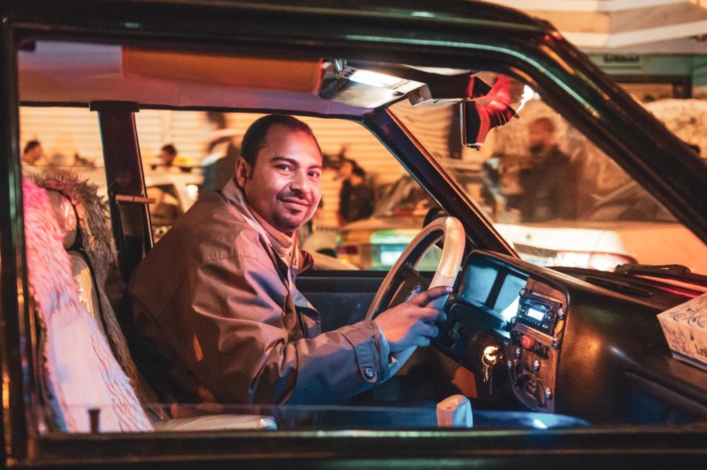 Man in taxi looking at camera and smiling